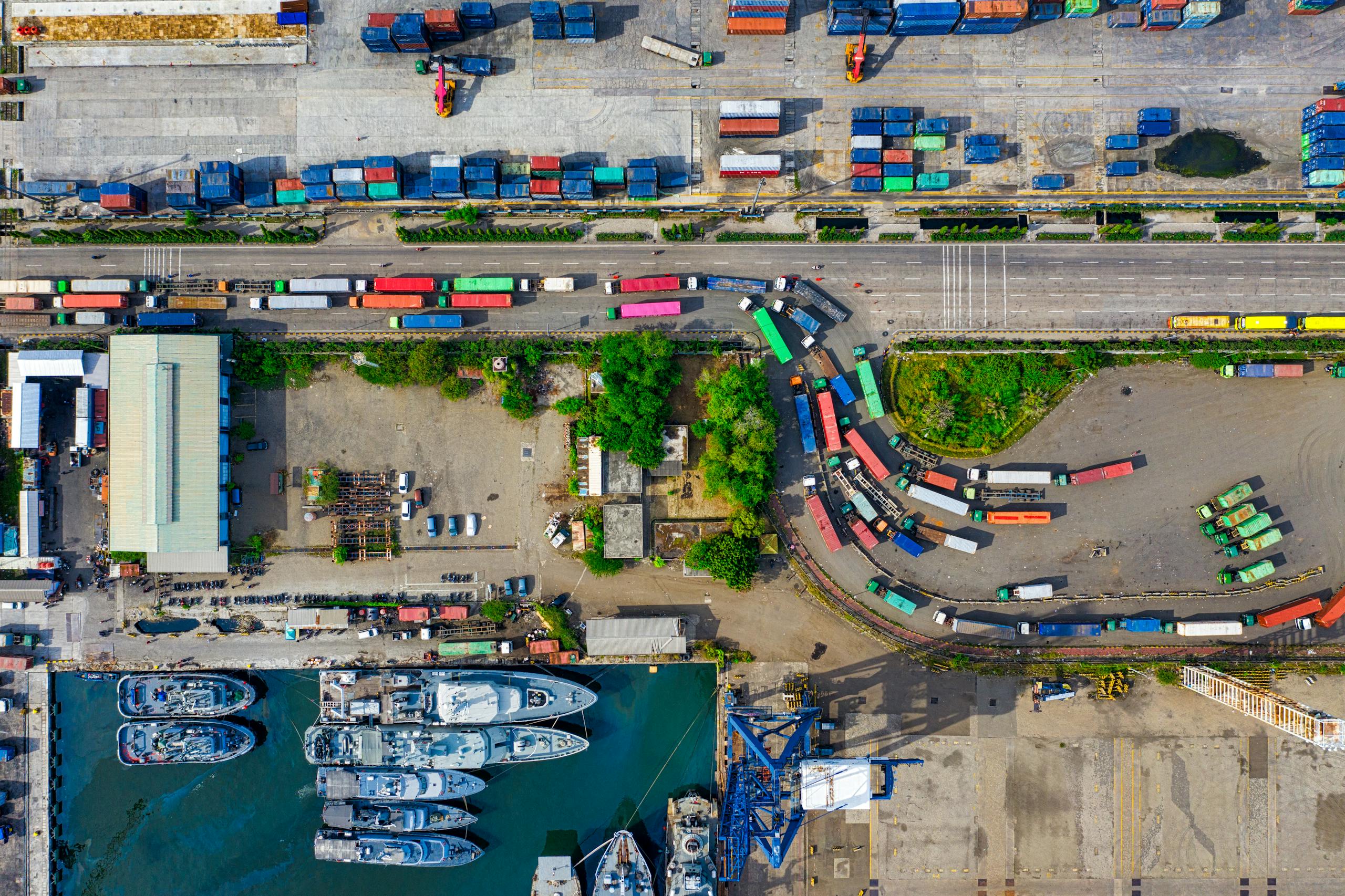 A vibrant aerial view of an industrial port with cargo containers in North Jakarta, Indonesia.