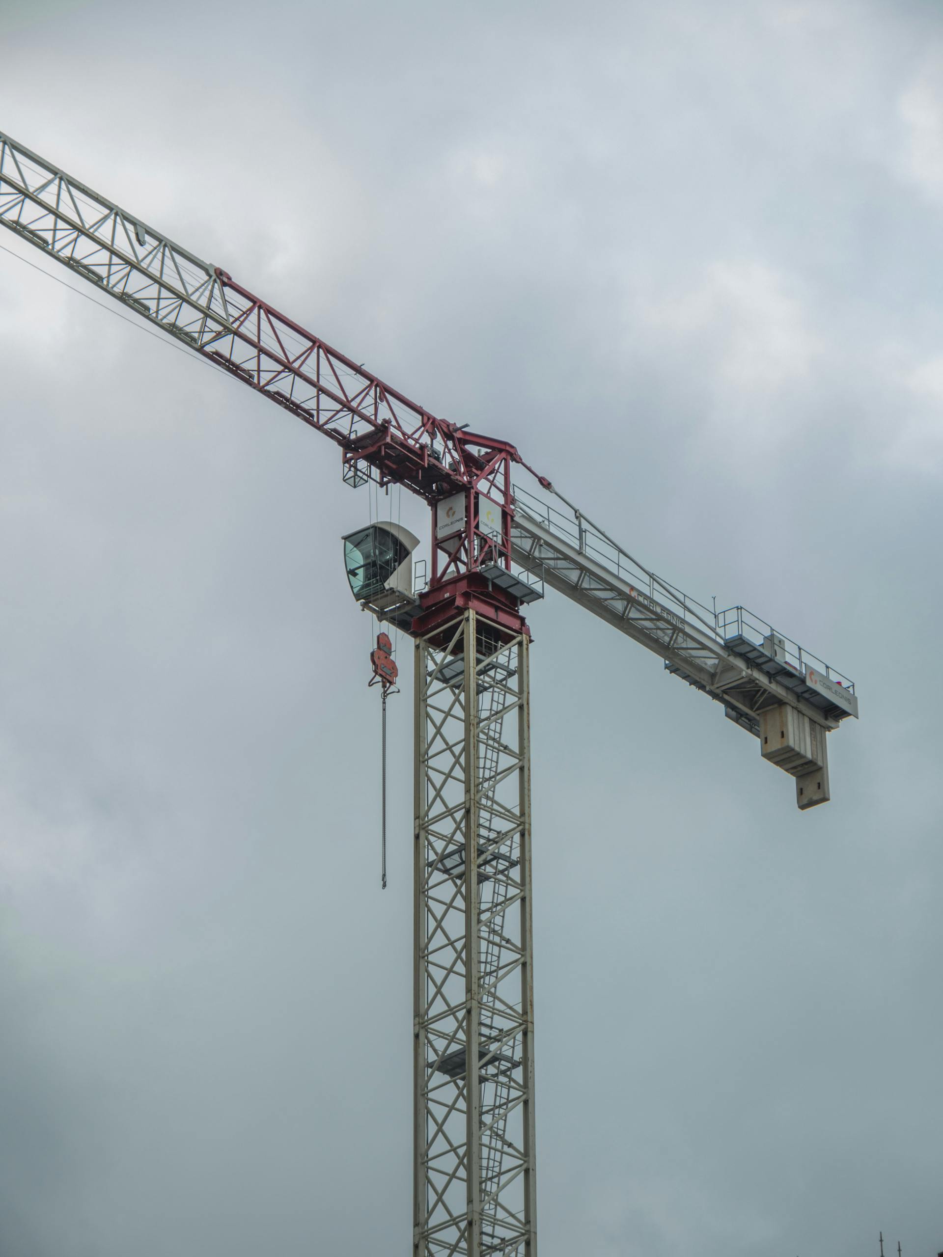 Tower crane in Wrocław's skyline on a cloudy day, capturing urban development.